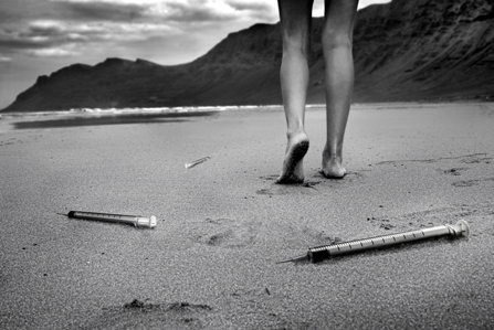 Girl on the beach, syringes